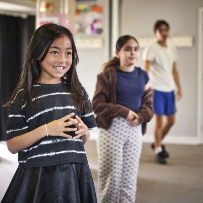 A girl smiles in her drama lesson
